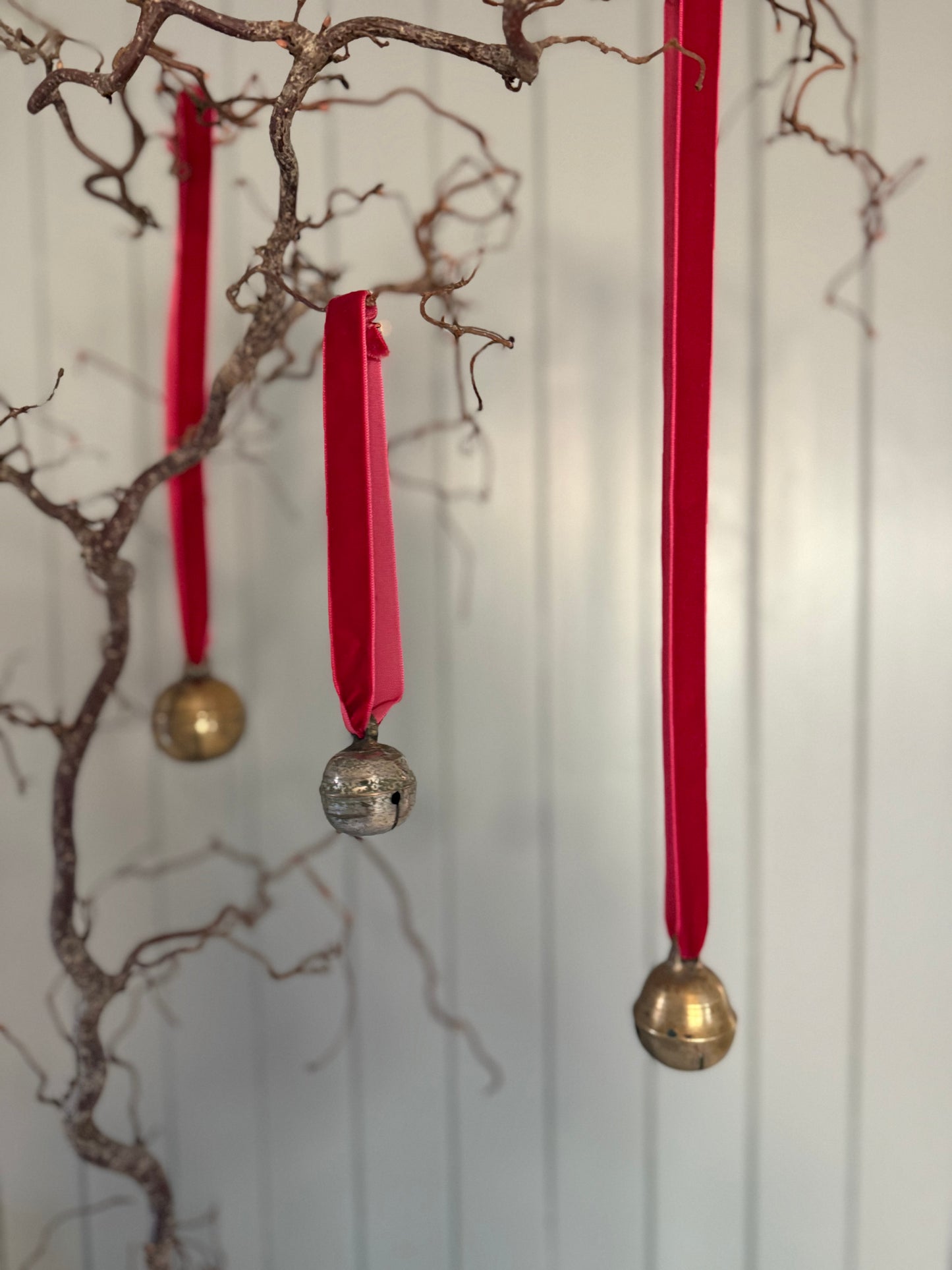 Dombjelle i messing med fløyelsbånd