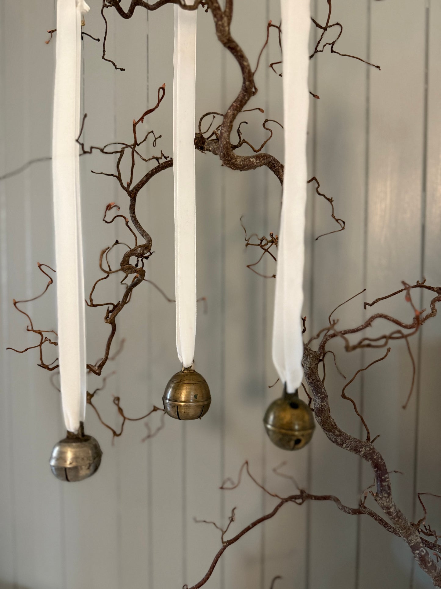 Dombjelle i messing med fløyelsbånd