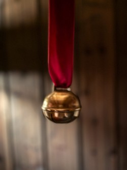 Dombjelle i messing med fløyelsbånd