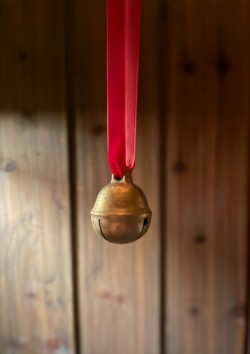 Dombjelle i messing med fløyelsbånd