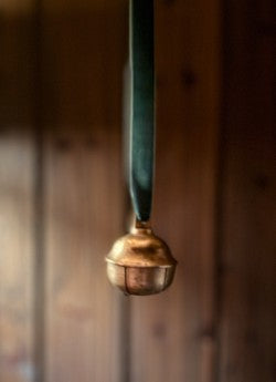 Dombjelle i messing med fløyelsbånd