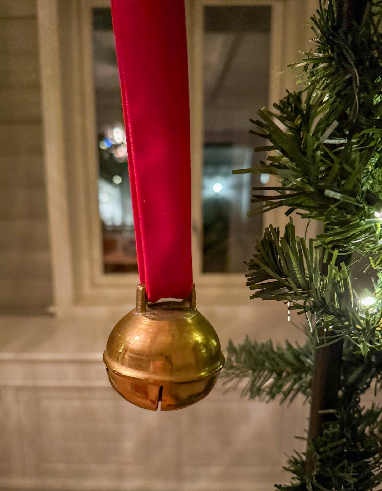 Dombjelle i messing med fløyelsbånd