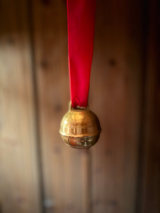 Dombjelle i messing med fløyelsbånd