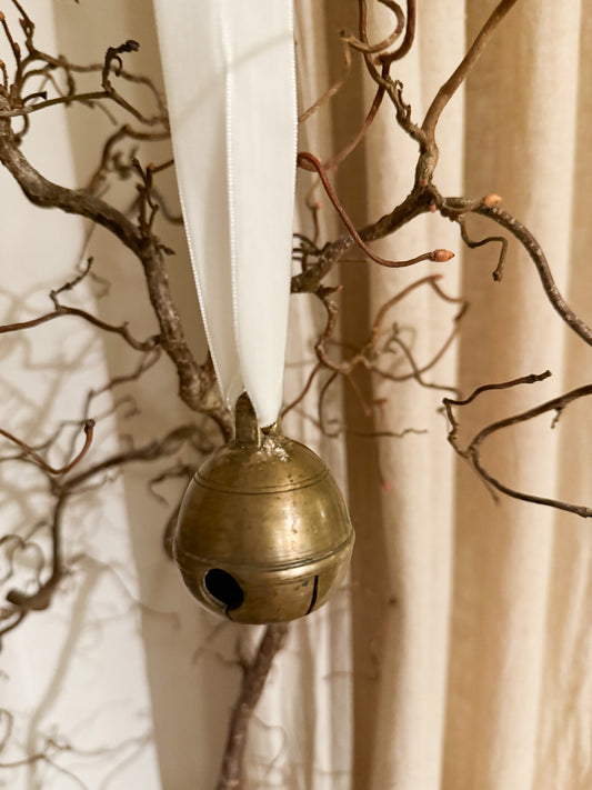 Dombjelle i messing med fløyelsbånd