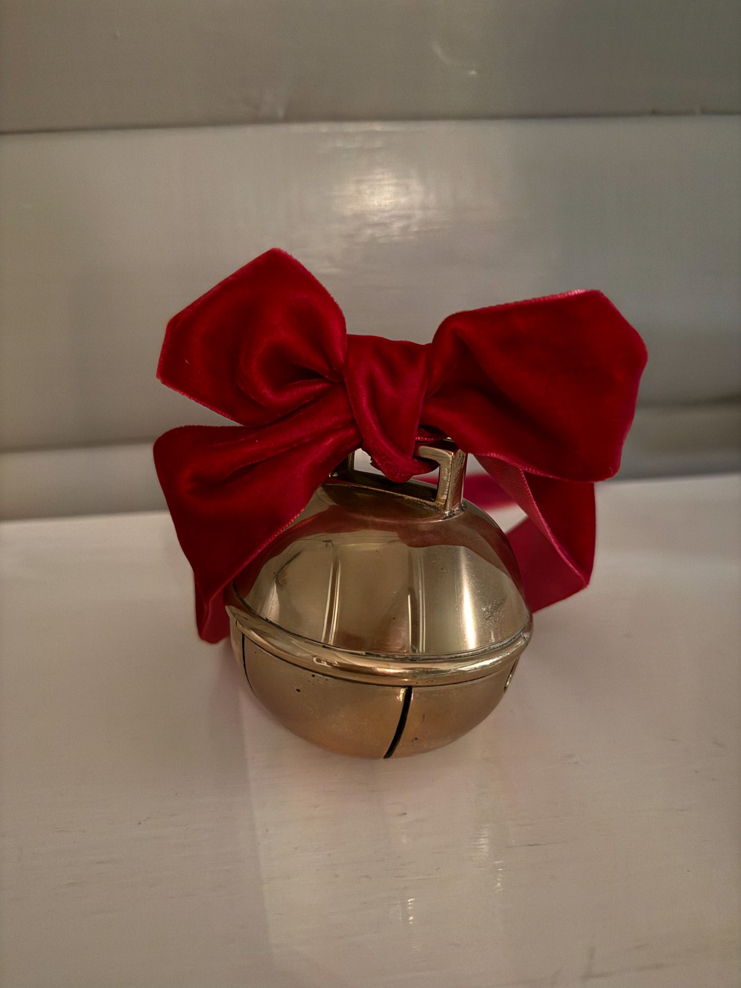 Dombjelle i messing med fløyelsbånd