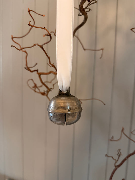 Dombjelle i messing med fløyelsbånd