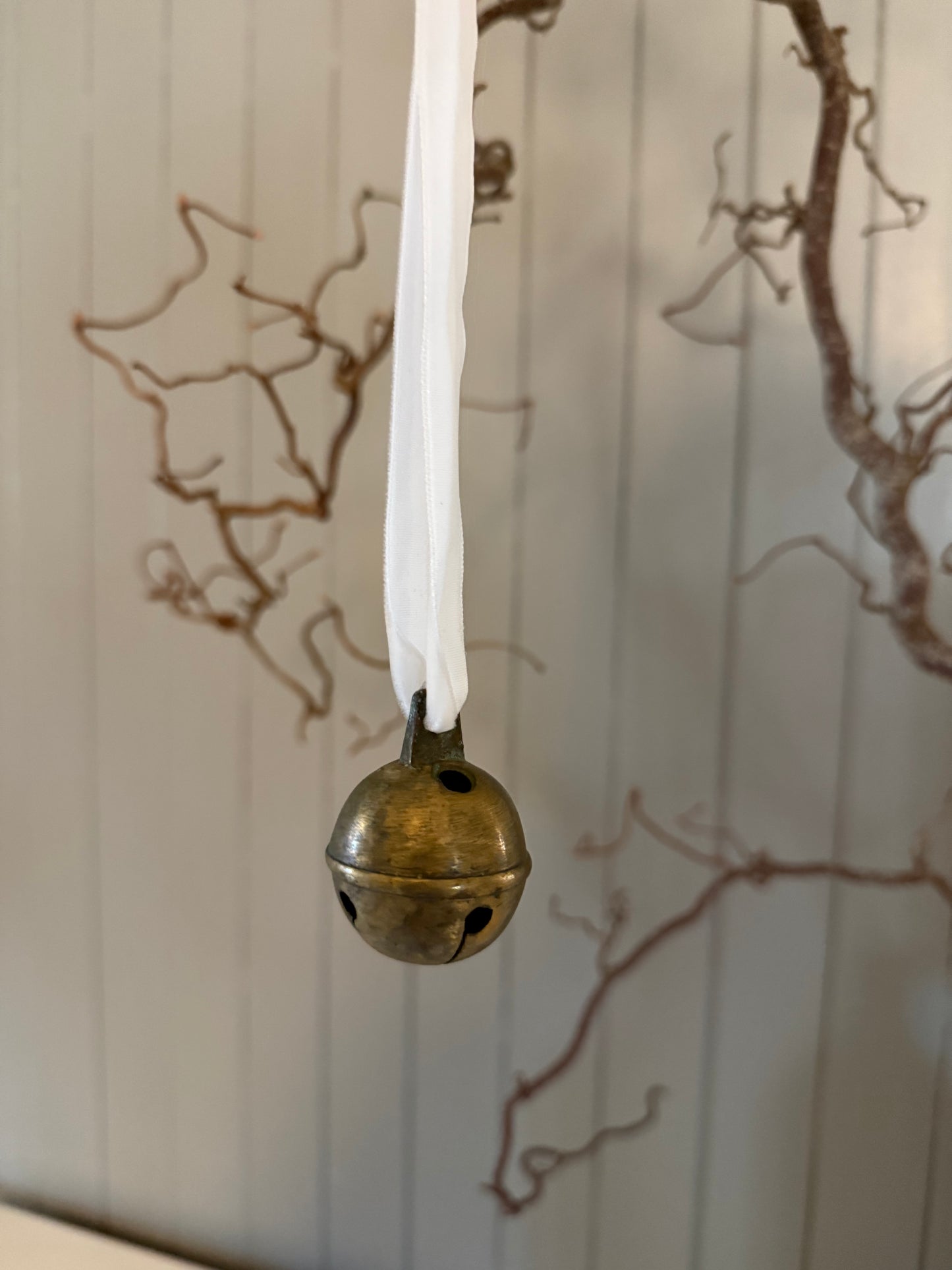 Dombjelle i messing med fløyelsbånd